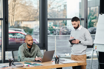 Two men deeply engrossed in their laptops, engaged in a collaborative coding session at a modern...