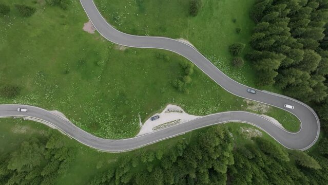Overhead perspective of vehicles navigating the meandering roads near Selva Pass in the Dolomite Mountains, Trentino, South Tyrol, Italy. LuPa Creative.
