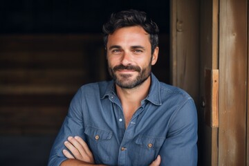 Obraz premium Portrait of a joyful man in his 30s sporting a versatile denim shirt isolated in empty modern loft background