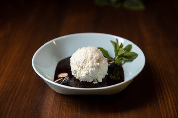white ice cream with chocolate souce in white dish