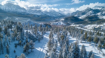 Aerial view of the Rocky Mountains, snow-dusted peaks and forested trails