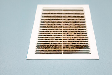 plastic ventilation grille filled with dirt, close-up.