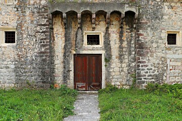 Old wooden door in an ancient stone house
