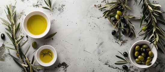 Olives of green and black hues sit in circular white bowls, accompanied by olive oil. The corners are adorned with branches from olive trees, forming a framed composition with room for text.