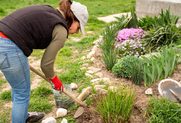 Gardener woman planting plants in the garden. Gardening concept.