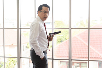 Businessman with gun in office and considers image of suicide