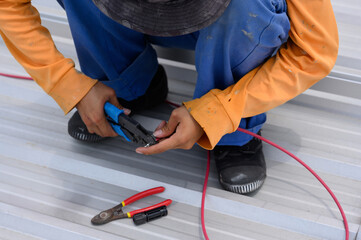 Close-up of a worker installing solar panels. A worker installs solar panels at a solar farm field.