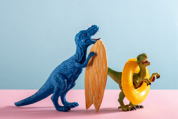 Two happy dinosaurs with surfboard and an inflatable circle on pink and blue background.