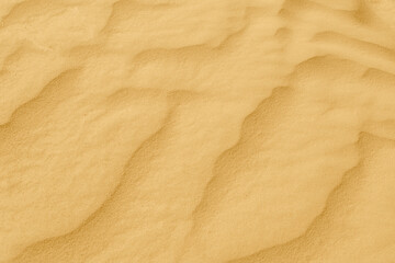 yellow desert sand shaped into waves by the wind