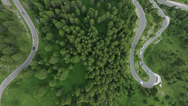 A bird's-eye view captures cars traversing the serpentine roads near Selva Pass in the Dolomites, Trentino, South Tyrol, Italy. LuPa Creative.