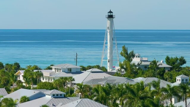 White lighthouse on sea shore for commercial vessels navigation at wealthy waterfront neighborhood in island small town Boca Grande on Gasparilla Island in southwest Florida, USA