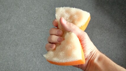 Man holding a sponge in his right hand for washing the body and shows it