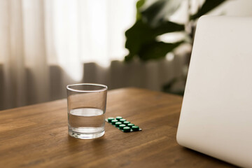 pill packet and a glass of water on the table