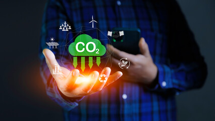 Carbon Credit Market and Net Zero in 2050. Carbon icon in hand on green background. Icon energy and environmental protection round green energy neutral carbon Net zero greenhouse gas emissions..