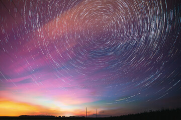 Bright Night Starry Sky. Soft Blue-orange-pink Colours. Amazing Star Trails On Night Sky Background. Trails Of Stars Above Power Line. Large Exposure. Fantasy, Illusion, Dream View.