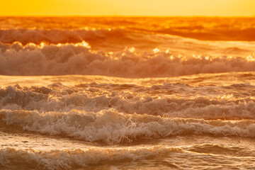 Sea water surface at sunset. Natural sunrise warm colors of ocean. Sea ocean water surface with foaming waves at sunset. Evening sunlight sunshine above sea. Amazing landscape scenery. Nature