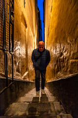 Stockholm, Sweden A man walks in the city's narrowest alley, Marten Trotzigs Grand in Gamla Stan or Old Town at night.