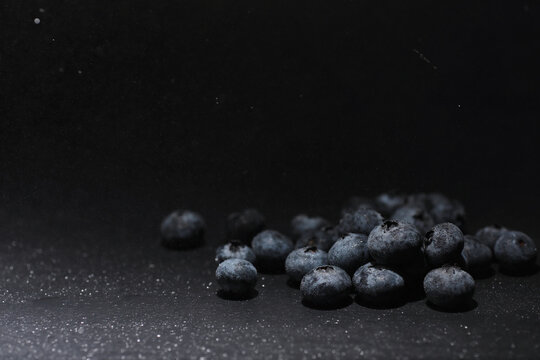 Water drops on ripe sweet blueberry. Fresh blueberries background with copy space for your text. Vegan and vegetarian concept. Macro texture of blueberry berries.