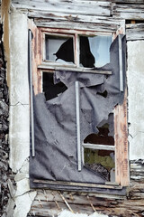 The seaside house has long been abandoned. An old ruined window in house on sea of Arctic Ocean