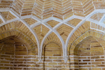 Brick arches with white accents inside historical bath (hammam) in Bukhara city. Warm lighting, perfect for historical themes. Bukhara (Buxoro), Uzbekistan - obrazy, fototapety, plakaty