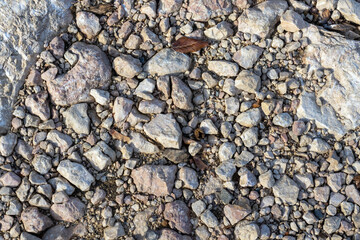 the texture of the riverbank with a rocky fraction and a sand-gravel mixture, a background for designers