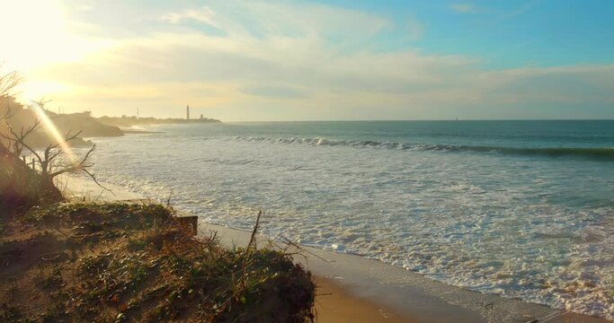 A beautiful sunset and white foaming waves rolling ashore at Ile de Re in France.