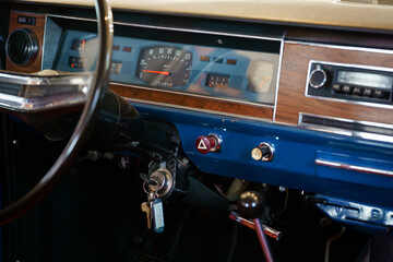 An old vintage car dashboard. A detail of the interior of an old vehicle. The ignition key is in the lock.