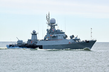 Russian warship armed with armament sails into sea toward military target to attack and destroy enemy, military ship performing strategic maneuver, Russian sea power deployment for tactical advantage