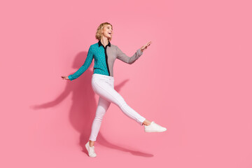 Full size photo of pretty young girl walking look empty space wear trendy striped cyan outfit...