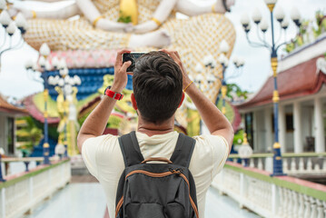 Tourist Capturing Temple Statue with Smartphone