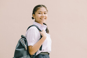 Portrait Thai Asian School girl teen cute student in uniform standing happy smile with shoulder bag isolated space for text.