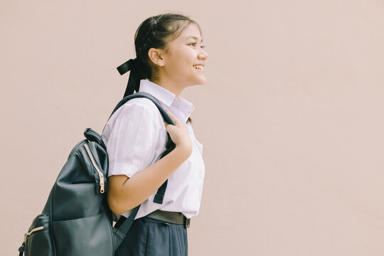 Portrait Thai Asian School girl teen cute student in uniform standing happy smile with shoulder bag isolated space for text.