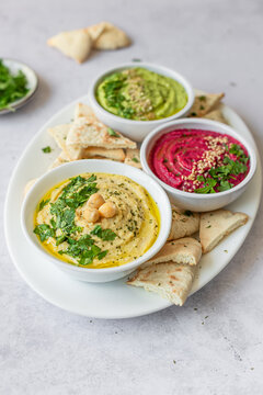 Trio of colorful hummus varieties with fresh herbs