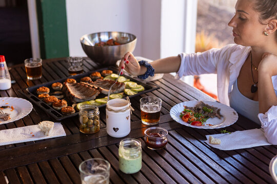 Family barbecue with woman cooking and grilled food