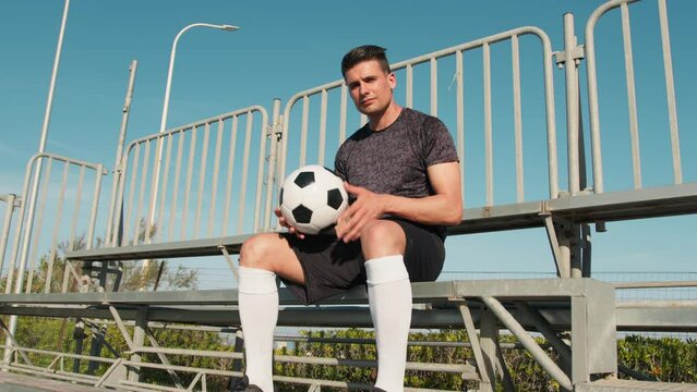 Neighborhood Boy Sitting In The Stands With The Soccer Ball In His Hand