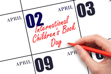 April 2. Hand writing text International Children's Book Day on calendar date. Save the date.