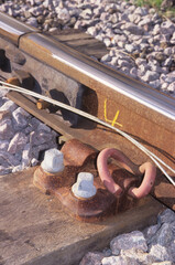 vertical image of railway track section with bolts, stones under lying lines, and chalk number markings at woodbridge rail station suffolk uk in 2003. closeup view.