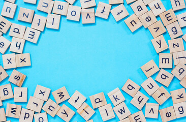 English letters scattered on blue background. Ideas for developing grammatical thinking and learning English, Magnifying glass with letters in English letters