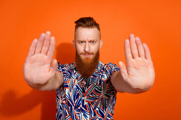 Photo of serious confident guy dressed print shirt showing arms palms asking stop isolated orange color background
