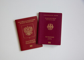 Top view of a German and a Russian passport on white table