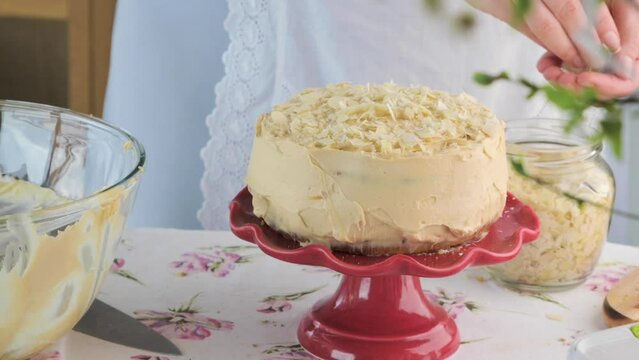 Large cake with cream and almond crumbs: inside with carrot cakes. Cake on the table with spring decor. Dark cake close-up. High quality FullHD footage