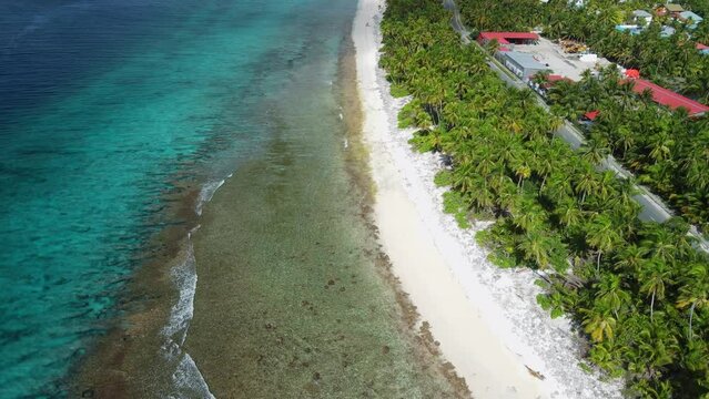 Tropical coastline with ocean, sandy beach and road in Fuvahmulah island. Aerial view