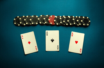 Poker game with a winning combination of three of a kind or set. Playing cards and chips on a blue...