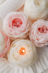 handmade candle in the shape of a flower on a light background, space for text