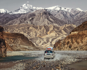 Off-road trip along an extreme road through a mountain canyon in Upper Mustang, Nepal. Beautiful view of the Himalayas - 789294627