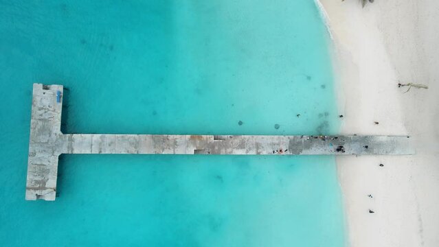 Aerial view of Maldives beach with pier and stingrays in ocean. Travel vacation concept.