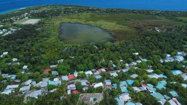 Fuvahmulah island in Maldives with local town, lake and ocean coastline. Aerial view