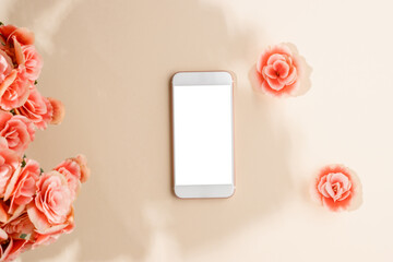 Smartphone mock up with white screen, pink flowers and sunlight shadows. Mobile phone with copy space for invitation, greeting, wedding, social media branding and design, top view, flat lay.