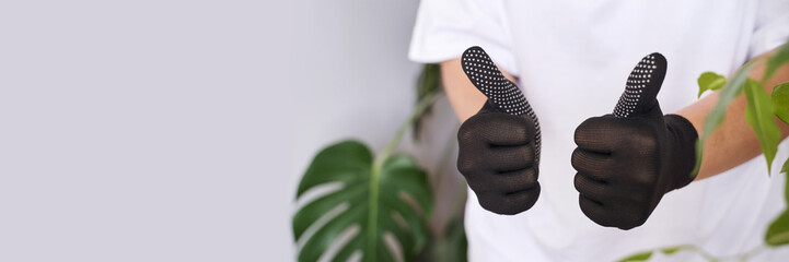 The hand wearing a rubber glove shows a thumbs-up sign, symbolizing safety and success in work. It conveys approval and positive communication. Satisfaction and protection