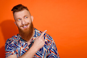 Photo of funky dreamy guy dressed print shirt showing finger looking emtpy space isolated orange...